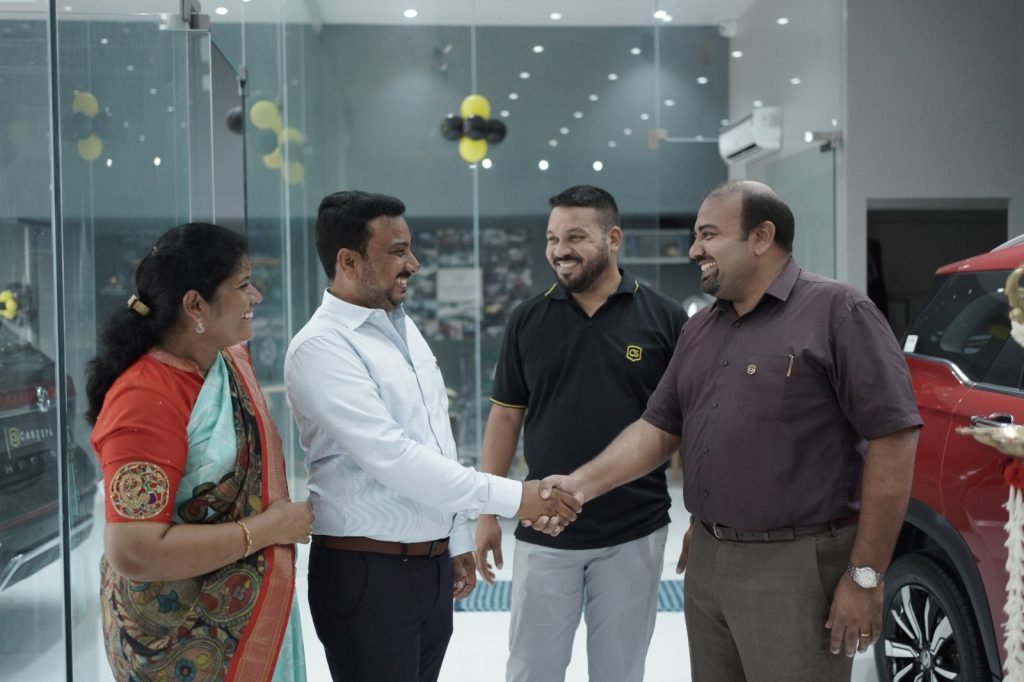 Two men shake hands as others look around